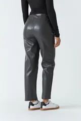 Pantalón de cuero sintético marrón, de tiro alto y corte recto, con pinzas y tablas en la parte delantera.
