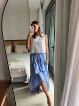 Pollera larga celeste de diseño fluido, confeccionada en algodón, con capas asimétricas, volados y cintura elástica.