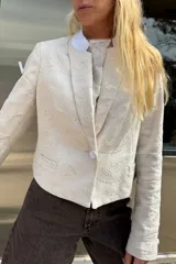 Blazer de lino color crema con bordado a tono en toda la prenda. Diseño sastrero con cuello solapa y cierre frontal con botones forrados.