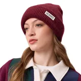 Gorro de lana tipo beanie de punto acanalado, color bordó, con etiqueta rectangular de la marca Rusty cosida en el frente.