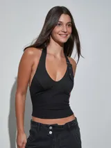 Top halter negro con detalle de tira y hebilla metálica en el hombro, con escote en V pronunciado y corte ajustado.