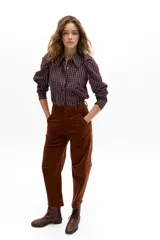 Camisa de manga larga con estampado de cuadros y bordados florales pequeños. Presenta cuello camisero clásico, cierre frontal con botones de nácar y hombros abullonados con frunces.