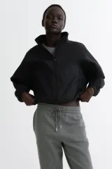 Pantalón deportivo de tiro alto confeccionado en felpa de mezcla de algodón con interior cepillado. Presenta cintura elástica con cordón de ajuste, bolsillos laterales al bies y puños elásticos en los bajos.