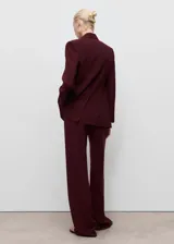 Pantalón de traje tiro medio, color bordó, de diseño recto y cierre posterior de cremallera.