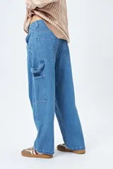 Pantalón jean negro de corte amplio y estilo carpenter, con tiro medio, bolsillos utilitarios y presillas laterales.