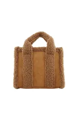 Cartera tipo tote bag de Las Oreiro, confeccionada en material efecto gamuza color beige con detalles de textura tipo corderito en las asas y bordes. Incluye un parche frontal con el logo de la marca y correa ajustable.