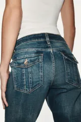 Jeans de tiro bajo y diseño bootcut, con efecto lavado, trabillas y cinco bolsillos clásicos. Cuenta con cierre frontal de cremallera y botón metálico.