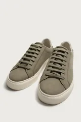 Zapatilla de estilo minimalista con cordones, confeccionada en material sintético de acabado mate. Presenta una horma redonda, forro interior en tono contrastante y suela de goma con textura ligera.