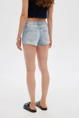 Short de jean tiro bajo y calce ajustado, con dobladillos deshilachados.