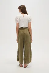 Pantalon de algodon negro de corte ancho y relajado, con cintura elastizada y cordon de ajuste. Presenta bolsillos laterales y una textura arrugada caracteristica del tejido.