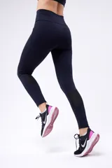 Calza negra de running de tiro alto, confeccionada en poliamida y elastano, con cierre en los tobillos.