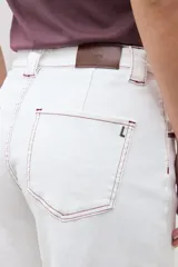 Jean culotte color crudo, de corte ancho y largo hasta el tobillo, con costuras visibles en contraste.