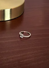 Anillo de plata 925 con una zirconia central de corte rectangular y pequeños cristales incrustados en los laterales del aro.
