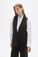 Chaleco negro sin mangas con solapas y un botón.