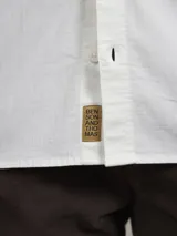 Camisa de manga larga color blanco con bolsillo en el pecho.