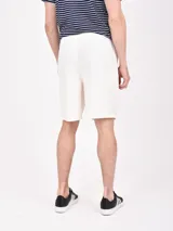 Bermuda de gabardina color beige, con cintura elástica ajustable con cordón, bolsillos laterales y traseros.