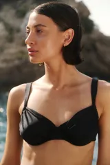 Conjunto de bikini negro de lycra brillante, compuesto por un corpiño con aro, tazas con frunces, breteles anchos regulables y tiras ajustables en la espalda, y una bombacha vedetina con tiras ajustables en los laterales.