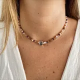 Gargantilla de cuentas de cristal color rosa, violeta y marrón, con dije de estrella plateada.