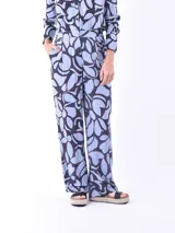 Pantalón de tiro alto, corte recto y ancho, con estampado de formas orgánicas en azul claro y azul oscuro.