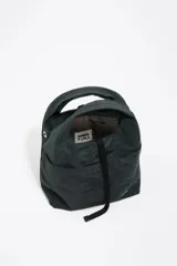 Bolso bandolera de estructura blanda marca Bimba y Lola, confeccionado en nylon con detalles en cuero. Presenta doble asa de mano, correa de tejido regulable y extraíble, cierre de cordón y logo metálico en el frente.