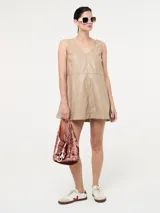 Vestido corto de eco cuero color beige, sin mangas, con escote en V y pespuntes a contratono.