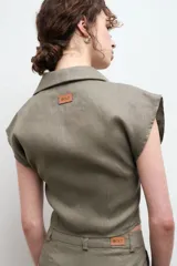 Camisa color beige claro de lino, con cuello clásico, abotonada al frente y sin mangas.