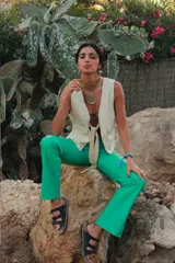 Pantalón de cuero de corte recto y tiro medio, color verde oscuro, con diseño artesanal y botón frontal.