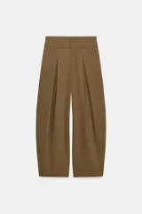 Pantalón balloon de tiro alto color negro con pliegues en el delantero y bolsillos laterales ocultos en la costura.