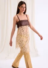 Top largo con cuerpo de cuero marrón chocolate y diseño inferior de crochet en tono beige, con tirantes finos y flecos laterales.