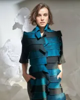 Bufandón de lana merino afieltrada color azul y negro, formado por piezas horizontales unidas que generan una textura continua.