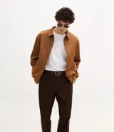 Pantalón de corte recto confeccionado en sarga de algodón con un toque de elastano. Presenta cintura con trabillas para cinturón, cierre tradicional de botón y cremallera, y bolsillos laterales y traseros.