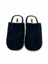 Pantufla abierta de pana azul marino con interior de corderito sintético color crema y suela plana.