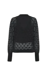 Sweater negro de punto con diseño de doble capa, que combina una base de cuello alto sin mangas con un sobre-sweater de escote en V y mangas largas con calados geométricos.