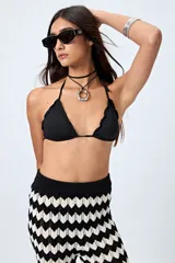 Top de bikini negro con tirantes finos y volados en el borde.