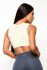 Top deportivo de entrenamiento con escote redondeado y espalda tipo nadador, confeccionado en poliamida tecnológica de alto rendimiento. Cuenta con forro interno y abertura para colocar almohadillas.