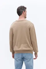 Sweater de cuello redondo con frente texturizado y mangas y espalda lisas. Confeccionado en algodón, presenta un diseño versátil ideal para usar en capas.