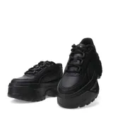 Championes Puma modelo Karmen X-TRA, de color negro con diseño robusto y plataforma elevada. Presentan un exterior sintético con texturas variadas, cordones al tono y detalles metálicos en los ojales superiores.