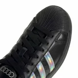 Championes Adidas modelo Superstar, color negro con las icónicas tres tiras laterales en acabado iridiscente y puntera de goma clásica.