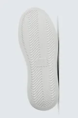 Zapatillas deportivas blancas de caña baja, con detalle de color negro en el talón y suela con volumen.