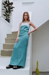 Vestido largo turquesa de tirantes con detalles de encaje blanco en el escote.