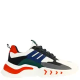Championes urbanos de diseño robusto, combinando paneles en negro y blanco con detalles vibrantes en color naranja en la suela y lengüeta. Presentan cierre mediante cordones y una suela gruesa con diseño ondulado.