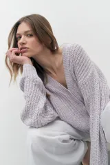 Cardigan lila de tejido de punto con escote en V y cierre con botones. Mangas largas y corte holgado.