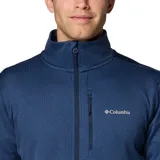 Campera polar de hombre con cierre frontal completo, cuello alto con protector de barbilla y bolsillos laterales y en el pecho con cierre. Cuenta con tecnología Omni-Wick, puños elásticos con orificios para el pulgar y tejido elástico.