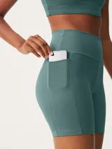 Bermuda deportiva rosada ajustada al cuerpo, con cintura alta y bolsillo lateral.