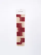 Pañuelo rectangular con diseño de franjas horizontales en color bordó y beige con efecto de bordes difuminados.