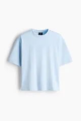 Remera celeste de corte oversized y diseño boxy en punto liviano de algodón, con hombros caídos y cuello redondo ribeteado acanalado.