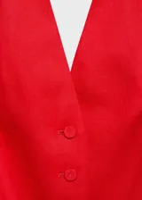 Chaleco rojo de lino con cuello halter, sin mangas, corte entallado, cierre frontal con botones y dos bolsillos de solapa laterales.