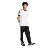 Pantalon deportivo Adidas modelo Firebird, color negro, con las icónicas tres tiras blancas laterales y logo del trébol bordado en la pierna. Presenta cintura elástica y corte recto.