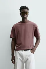 Camiseta color arena de algodón compacto, corte recto, cuello redondo y mangas cortas.