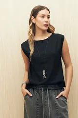 Top sin mangas de lino y viscosa, color negro, con escote redondo y caída relajada. Presenta hombros levemente marcados y botones forrados en la espalda.